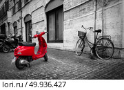 Rome, Italy - June 18, 2016. Small red motorbike on roman street, Italy. Street in Rome. Редакционное фото, агентство Ingram Publishing / Фотобанк Лори