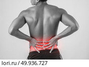 Close up of man rubbing his painful back isolated on white background.. Close up of man rubbing his painful back isolated on white backg. Стоковое фото, агентство Ingram Publishing / Фотобанк Лори