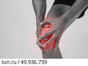 Young sport man with strong athletic legs holding knee with his hands in pain after suffering ligament injury  isolated on white.. Young sport man with strong athletic legs holding knee with his . Стоковое фото, агентство Ingram Publishing / Фотобанк Лори