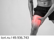 Young sport man with strong athletic legs holding knee with his hands in pain after suffering ligament injury  isolated on white.. Young sport man with strong athletic legs holding knee with his . Стоковое фото, агентство Ingram Publishing / Фотобанк Лори