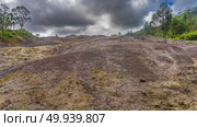 The unique landscape of Mauritius, 23 coloured earth. Colorful sand hill. Green vegetation on the slope. Blue sky, dark clouds. La Vallée Des Couleurs Nature Park. Стоковое фото, фотограф Вера Ивановна Кубарева / Фотобанк Лори