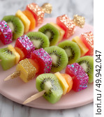 Colorful glittered fruit skewers with kiwi and watermelon on pink plate. Стоковое AI-изображение, AI-художник Olga Didraga / Фотобанк Лори