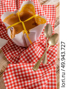 Portuguese sponge cake wrapped in the typical paper used on the baking, on wooden background. Стоковое фото, агентство Ingram Publishing / Фотобанк Лори