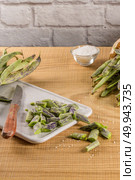 Green kidney bean on brown wooden cutting board with kitchen knife. Стоковое фото, агентство Ingram Publishing / Фотобанк Лори