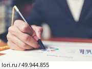 Close up hands signing terms of agreement documents of businessman on his desk, business signing concept. Стоковое фото, агентство Ingram Publishing / Фотобанк Лори