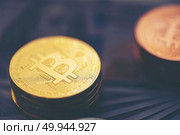 Physical version of Bitcoin (new virtual money) and banknotes of one dollar. Exchange bitcoin for a dollar. Conceptual image for worldwide cryptocurrency and digital payment system. Стоковое фото, агентство Ingram Publishing / Фотобанк Лори