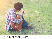 Young hipster man practiced guitar in the park,happy and enjoy p. Young hipster man practiced guitar in the park,happy and enjoy playing guitar. Стоковое фото, агентство Ingram Publishing / Фотобанк Лори