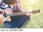 Young hipster man practiced guitar in the park,happy and enjoy p. Young hipster man practiced guitar in the park,happy and enjoy playing guitar. Стоковое фото, агентство Ingram Publishing / Фотобанк Лори