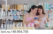 Portrait of attentive mother and daughter choosing box with pills to improve well-being in pharmacy, scan QR code on label. Стоковое видео, видеограф Яков Филимонов / Фотобанк Лори