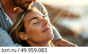 A woman rests her head on a mans chest, embraced lovingly as sunlight bathes their faces. Стоковое AI-изображение, AI-художник Данила Большаков / Фотобанк Лори