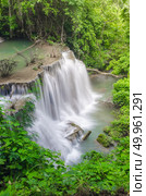 Erawan Waterfall, beautiful waterfall with sunlight rays in deep forest, Erawan National Park in Kanchanaburi, Thailand. Стоковое фото, агентство Ingram Publishing / Фотобанк Лори