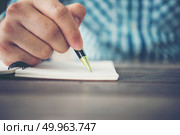 Close up of man hand writing in notebook with pen. Стоковое фото, агентство Ingram Publishing / Фотобанк Лори