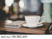 Cup of coffee with book in coffee shop vintage color blurred caf. Cup of coffee with book in coffee shop vintage color blurred cafe background. Стоковое фото, агентство Ingram Publishing / Фотобанк Лори
