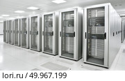 A lineup of high-tech servers fills a vast room, displaying a network hub with blinking lights and cables. Стоковое AI-изображение, AI-художник Данила Большаков / Фотобанк Лори