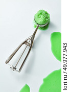 Scoop home made ice cream. Greens melting ice cream with a pattern of splashes on a gray background with a copy of the space for text. Cold summer dessert. Top view. One scoop of pistachio ice cream on a gray background with splashes and a copy of space. Top view. Стоковое фото, агентство Ingram Publishing / Фотобанк Лори