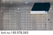 Aerial top view from a flying drones to a parking lot for cars with numbered seats with long shadows from truck, lampposts and camps on a sunny day.. Parking lot, marking parking spaces with a long truck and shadows from all objects located on it on a sunny summer day. Стоковое фото, агентство Ingram Publishing / Фотобанк Лори