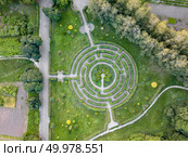 The part of Botanical garden with labyrinth round shape. Aerial view from the drone at the evenung in summer day.. Birds eye view from the drone to a Garden labyrinth of green shrubs in the park. Стоковое фото, агентство Ingram Publishing / Фотобанк Лори