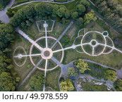 Aerial view from the drone to park alleys of round shape with trees and bushes in the garden at sunset in a summer day.. Park alleys of round shape in the botanical garden. The photo from the drone is strictly from above. Стоковое фото, агентство Ingram Publishing / Фотобанк Лори