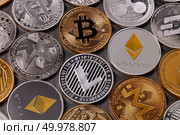 Gold and silver coins, LTC, ETH, BTC, XMR, XRP. A pattern from different coins of virtual currency on a dark background. Cryptocurrency and blockchain concept. Top view. Many different coins of crypto currency on a dark background. Business and technology concept. Top view. Стоковое фото, агентство Ingram Publishing / Фотобанк Лори