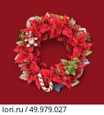 Christmas twig wreath is decorated with candy, red flowers, cookies and green leaves.. Christmas twig wreath. Стоковое фото, агентство Ingram Publishing / Фотобанк Лори