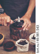 Vintage coffee grinder and beans on wooden background. Стоковое фото, агентство Ingram Publishing / Фотобанк Лори