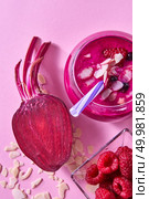 Organic freshly picked vegetables and fruits for preparing healthy vegetarian smoothie in a glass jar on pink paper. Flat lay.. Homemade red smoothies with beet, raspberries and black currants, almond flakes on a pink paper background. Стоковое фото, агентство Ingram Publishing / Фотобанк Лори