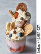 Delicious oats with yoghurt, berries and snack in a glass on a concrete background. Healthy delicious dessert. yogurt with muesli and berries on a concrete background. Стоковое фото, агентство Ingram Publishing / Фотобанк Лори