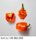 Set of different slices of sweet yellow peppers isolated on a gray background. Healthy eating diet food concept top view. Opened , whole yellow bell pepper and slices on gray background. Стоковое фото, агентство Ingram Publishing / Фотобанк Лори