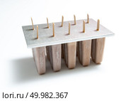 Chocolate ice cream Ice lollies in plastic molds with shadows on white background with space for text. Cooling summer dessert. Homemade organic chocolate ice cream lolly in plastic molds with a reflection of shadows on a white background with copy space. Стоковое фото, агентство Ingram Publishing / Фотобанк Лори