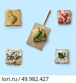 different sandwiches with different ingredients. one sandwich on a wooden kitchen board on a blue background flat lay. different sandwiches on a blue background. Стоковое фото, агентство Ingram Publishing / Фотобанк Лори