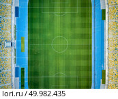 KIEV, UKRAINE - July 19, 2018. Birds eye view from drone of the stadium - National Sports Complex Olimpiysky green grass of football field and seats of tribunes before soccer match at summer sunset.. KYIV, UKRAINE - July 19, 2018. NSC Olimpiysky. Aerial view from drone of construction of green football field, tribunes before the game. Top view. Редакционное фото, агентство Ingram Publishing / Фотобанк Лори