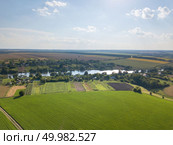 Panoramic view from the drone, aerial photography of landscape with greenery of forests, agricultural fields on the background of the cloudy sky at sunset.. Amazing countryscape with green fields, river, greenery and blue cloudy sky in a summer time. Стоковое фото, агентство Ingram Publishing / Фотобанк Лори