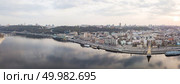 Aerial panoramic view from the drone on the central historical part of the city Kiyv, and the district of Podil with the Postal square, hotels, churches, river Port. Reflection of sunset and cloudy sky in the Dnieper River.. The full panorama bird’s eye view shooting from drone of the Podol district, the right bank of the Dnieper River and centre of Kiev, Ukraine summer evening at sunset on the background of the cloudy sky. Стоковое фото, агентство Ingram Publishing / Фотобанк Лори