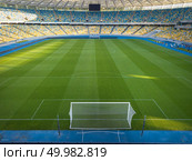 KIEV, UKRAINE - July 19, 2018. National Sports Complex Olimpiysky, panoramic view to a football field, tribune and treadmills of stadium in a summer time before match. Aerial view from drone. KYIV, UKRAINE - July 19, 2018. Perspective view of NSC Olimpiysky - the inside part with a green football field, tribunes and treadmills. Редакционное фото, агентство Ingram Publishing / Фотобанк Лори