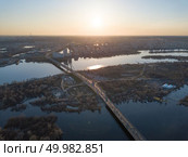 view landscape on the North bridge over the Dnieper River overlooking the Skaimol shopping center and Obolon district, on the left side of Kiev on the sunset, Ukraine. Photo from the drone. North bridge over the Dnieper River overlooking the Skaimol shopping center and Obolon district on the sunset. Стоковое фото, агентство Ingram Publishing / Фотобанк Лори