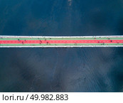 Aerial top view of Pedestrian Bridge, the only bridge constructed specifically for the pedestrian traffic over the Dnieper fairway in Kiev, Ukraine. Drone photo. People are walking on the pedestrian bridge in Kiev on a spring day. View from above. Стоковое фото, агентство Ingram Publishing / Фотобанк Лори