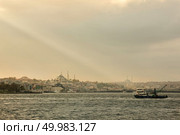 View of the old historical building with mosques, towers, buildings in the eastern style, cargo ships, tugboats in the port on the roadstead.. Landscape panoramic view from the sea to the historical part of Istanbul, Turkey. Стоковое фото, агентство Ingram Publishing / Фотобанк Лори