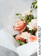 Composition of flowers of white or orange roses represented on grey background. Decoration of grey background in Valentine’s Day. Holiday concept.. Bouquet of roses for holiday. Стоковое фото, агентство Ingram Publishing / Фотобанк Лори