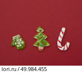 Christmas gingerbread cookies with color icing on a red background. Christmas gingerbread cookies with icing. Стоковое фото, агентство Ingram Publishing / Фотобанк Лори