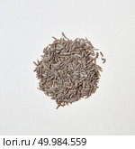 Natural organic herbal cumin - spice for cooking homemade healthy eating on a white with copy space. Healthy eating background. Flat lay. A round pattern of natural herb cumin seeds isolated on white background. Стоковое фото, агентство Ingram Publishing / Фотобанк Лори