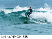 Surfer in action on the ocean waves on a cloudy day. Стоковое фото, агентство Ingram Publishing / Фотобанк Лори
