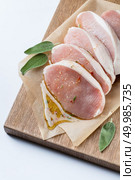 Raw meat. Pork escalope with sause made of honey and herbs with green sage leaves on wooden board against white background. Top view. raw pork escalope with sause made of honey and herbs. Стоковое фото, агентство Ingram Publishing / Фотобанк Лори