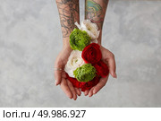a bouquet of fresh flowers, a girl with a tattoo on her hands holding flowers on a gray background. The concept of a greeting card top view. girl with a tattoo on her hands holding a bouquet of flowers. Стоковое фото, агентство Ingram Publishing / Фотобанк Лори