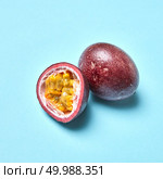 Ripe organic passion - exotic tropical fruit on a pastel blue background with place under text.. Passion fruit, passionfruit, maraquia whole and half isolated on white background. Стоковое фото, агентство Ingram Publishing / Фотобанк Лори