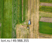 Panoramic view of plowing the ground after harvesting on the field in the summer time. Aerial top view from the drone of the field after harvest. Agricultural field after harvesting and combine harvester reaps a crop, red car on a field. Aerial view from the drone. Top view. Стоковое фото, агентство Ingram Publishing / Фотобанк Лори