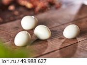 Fresh boiled peeled quail eggs on an old wooden background with reflection of shadows. Healthy food. Cooking peeled quail eggs presented on an old wooden table. Ingredient for Healthy Salad. Стоковое фото, агентство Ingram Publishing / Фотобанк Лори