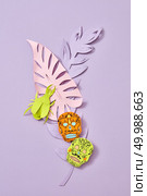 Handcraft composition of multi-colored paper leaves and Calaveras attribute of the Mexican holiday of Calaca on a purple background with space for text. Halloween card. Flat lay. The pattern of handcraft paper Calaveras attribute of the Mexican holiday of Calaca and colored leaves on a purple background with space for text. Layout to halloween. Flat lay. Стоковое фото, агентство Ingram Publishing / Фотобанк Лори