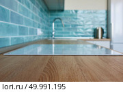 View of a brown kitchen countertop with a white hob in a modern kitchen with a blue tile. View of the kitchen brown countertop with white hob. Стоковое фото, агентство Ingram Publishing / Фотобанк Лори