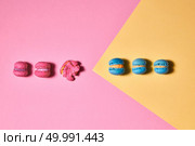 Set of blue and pink macaroons, one macaroon crushed on a pink yellow paper background. Flat lay. Row of different macaroons on a yellow pink background. Creative layout for your ideas. Flat lay. Стоковое фото, агентство Ingram Publishing / Фотобанк Лори
