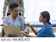 Physical therapist explain treatment method to senior patient and relative using notebook. Стоковое фото, агентство Ingram Publishing / Фотобанк Лори